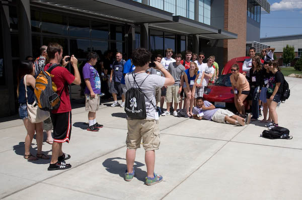 Students posing about Tesla Roadster at CWU